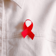 Red ribbon pinned to a white shirt